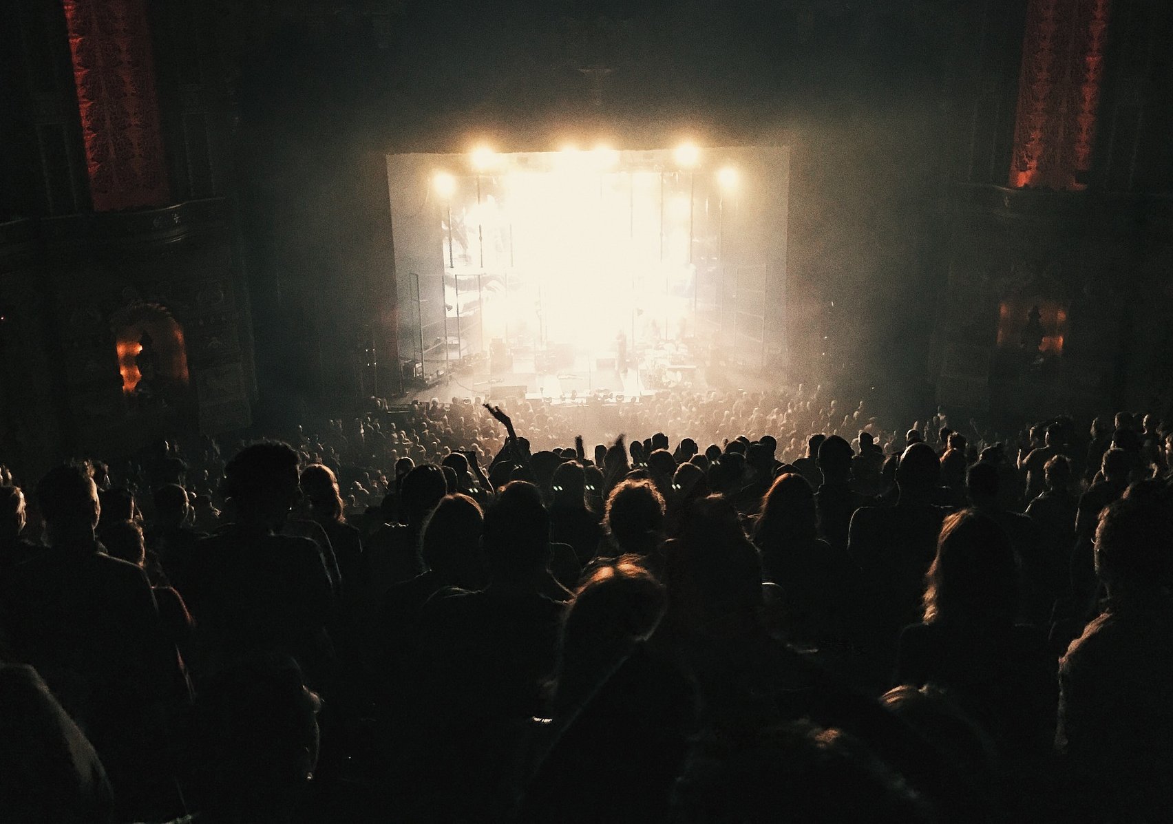 Image of an audience and a stage that is backlit